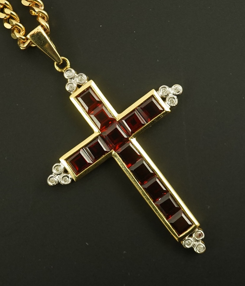 A modern 18ct gold, garnet and diamond chip cluster set cross pendant, 42mm, gross weight 6.5 grams, on a modern 9ct gold curb link chain